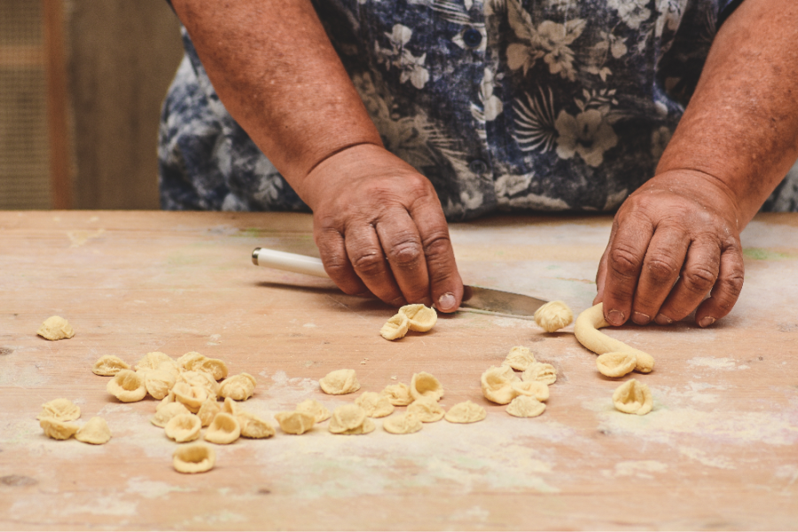 Hands of a local woman in the street of Bari old town making orecchiette or orecchietta handmade pasta made with durum wheat and water typi_edited